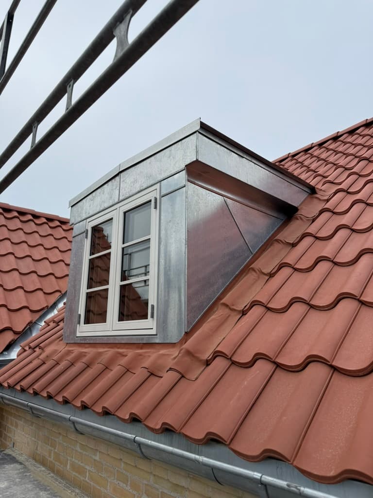 Nyt tegltag med røde teglsten og kvist — reelt tagprojekt